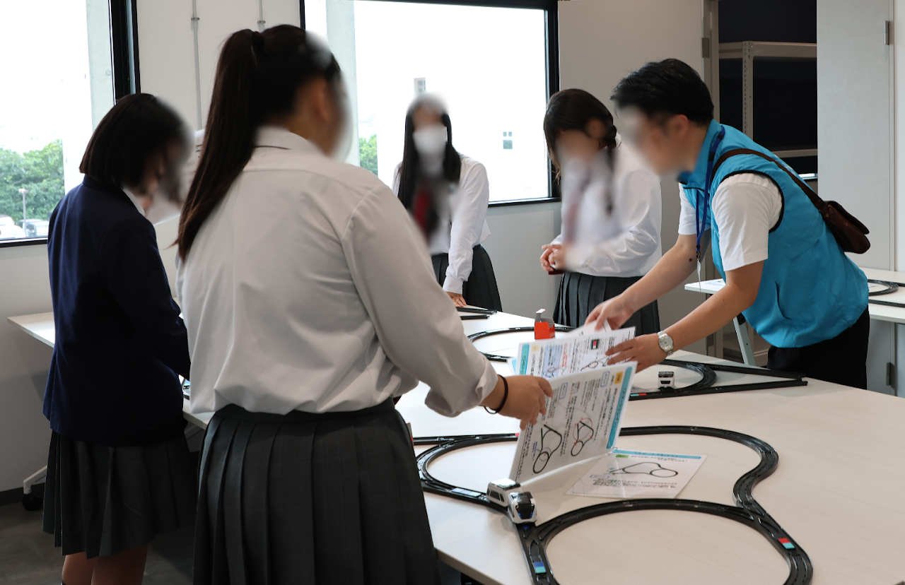 複数の線路と学習資料を用意するイベントスタッフ